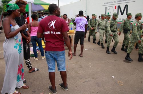 Migrantes africanos y haitianos, atentos al arribo de elementos de la Marina para reguardar las instalaciones del INM en Tapachula, Chiapas. Foto Luis Castillo.