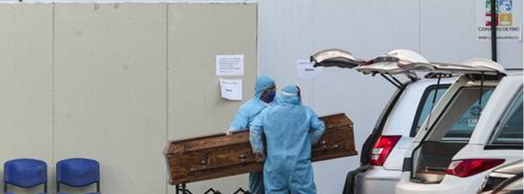 Trabajadores de una funeraria de Chile trasladan el cuerpo de una víctima de coronavirus en un hospital de Santiago. Foto Ap
