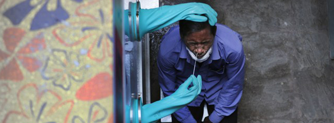Un trabajador de salud toma una muestra de una persona para realizar una prueba de coronavirus, en un hospital de Nueva Delhi, India. Foto Ap