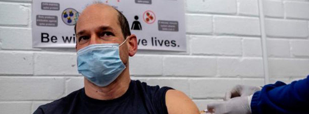 El profesor Francois Venter (izq.) recibe una vacuna experimental para el coronavirus covid-19 en la Unidad de Investigación de Patógenos Respiratorios y Meníngeos (RMPRU) en el Hospital Chris Hani Baragwanath en Soweto, el 14 de julio de 2020. Foto: AFP