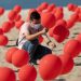 Un hombre coloca globos rojos en la arena de la playa de Copacabana en una manifestación organizada por Río de Paz para honrar a las víctimas del Covid-19. Foto AP