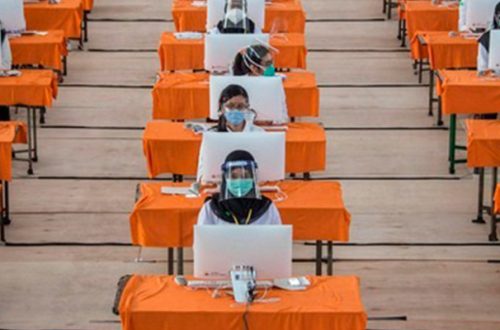Empleados estatales con indumentaria contra el coronavirus presentan una prueba en Surabaya, Indonesia. Foto Afp