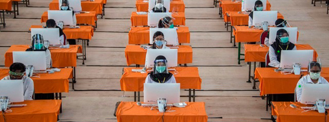 Empleados estatales con indumentaria contra el coronavirus presentan una prueba en Surabaya, Indonesia. Foto Afp
