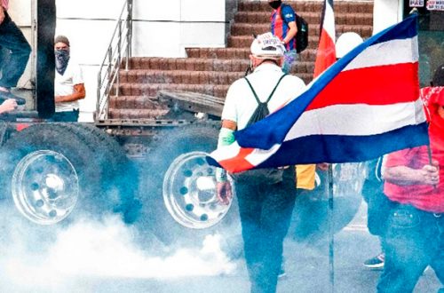 Manifestantes tratan de alejarse de gases lacrimógenos lanzados por la policía, en San José, Costa Rica, el 12 de octubre de 2020, durante protestas contra el intento del gobierno de aumentar impuestos para alcanzar un crédito del FMI. Foto Afp