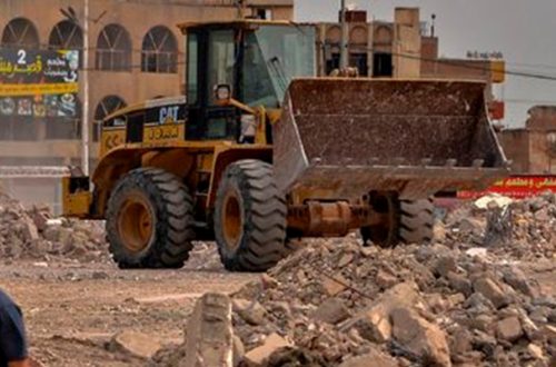 Un trabajador retira escombros con una excavadora en la antigua ciudad de Mosul, al norte de Irak. Foto Afp