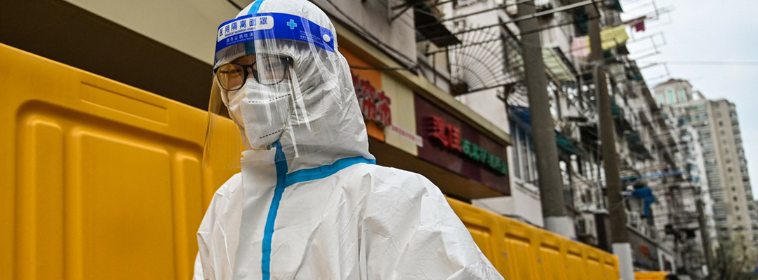 Un trabajador camina junto a las barreras que confinan un barrio como medida contra el aumento de contagios de covid-19 en el distrito de Jing'an, en Shangái, China, el 30 de marzo de 2022. Foto Afp
