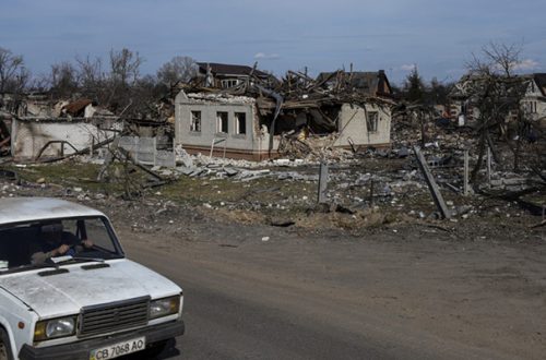 Un auto pasa por una calle con casas dañadas en Chernígov, Ucrania, el 7 de abril de 2022. Foto Ap