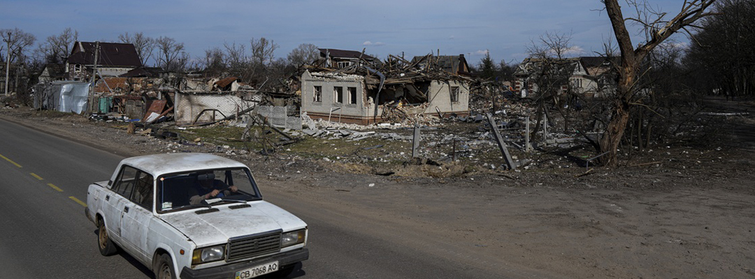 Un auto pasa por una calle con casas dañadas en Chernígov, Ucrania, el 7 de abril de 2022. Foto Ap