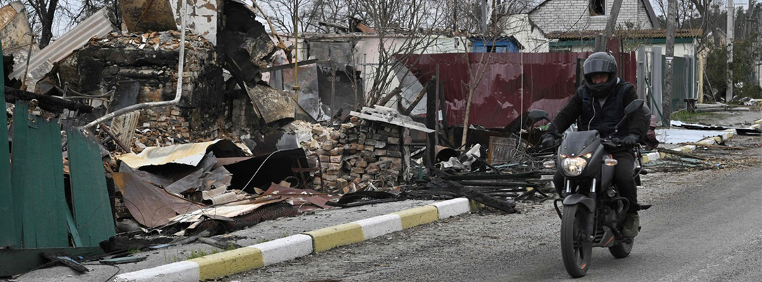 Un motociclista frente a una casa destruida en el pueblo de Moshchun, al noroeste de Kiev, el 20 de abril de 2022. Foto Afp