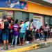 Pie de Foto.- Largas filas de migrantes para cobrar remesas en un Oxxo de Tapachula, Chiapas. Foto Edgar H. Clemente