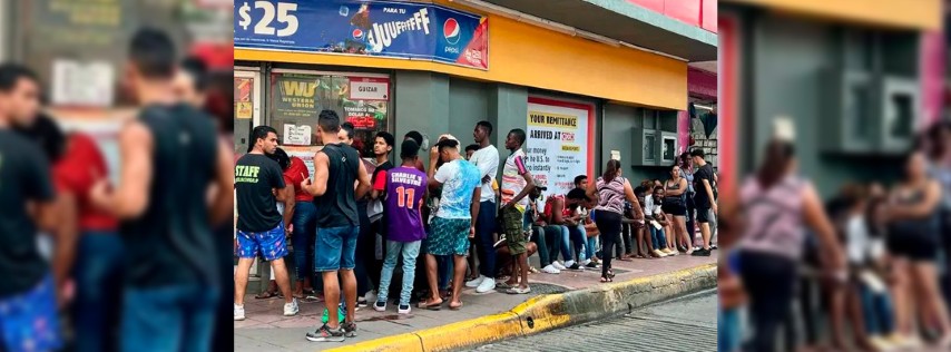 Pie de Foto.- Largas filas de migrantes para cobrar remesas en un Oxxo de Tapachula, Chiapas. Foto Edgar H. Clemente