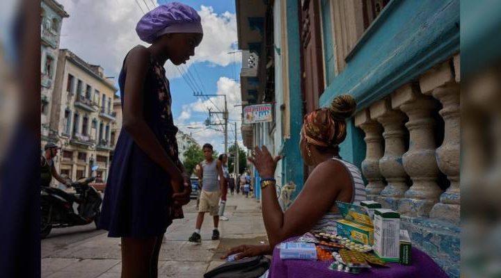 Pie de Foto.- Una mujer vende medicamentos en una mesa cubierta con una toalla en una calle de La Habana, Cuba, el 8 de octubre de 2026. Foto Ap